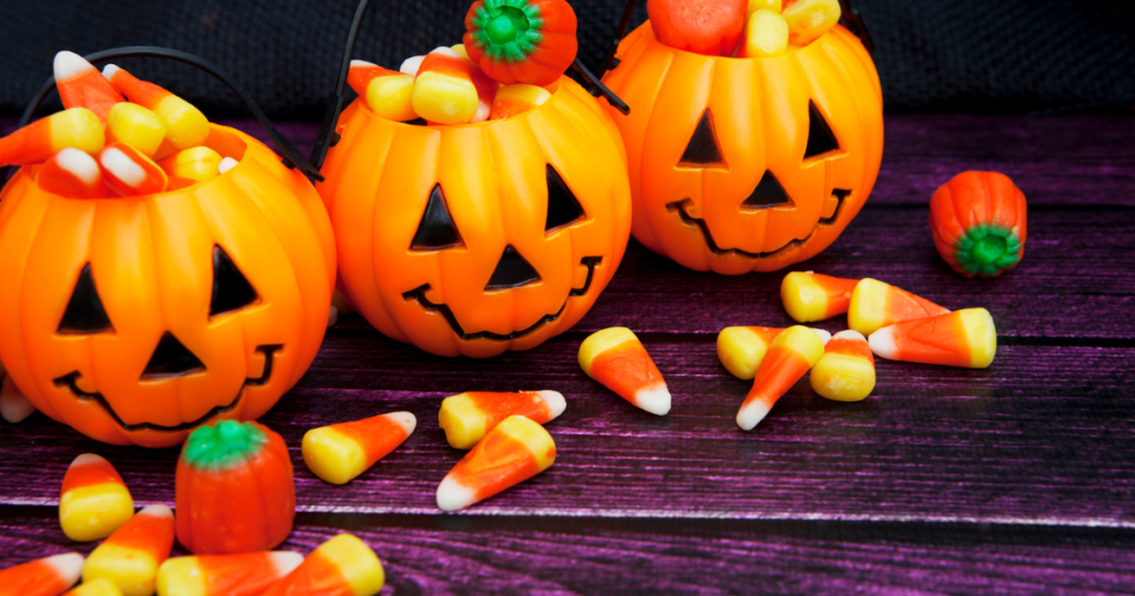 Candy corn overflowing from plastic pumpkins