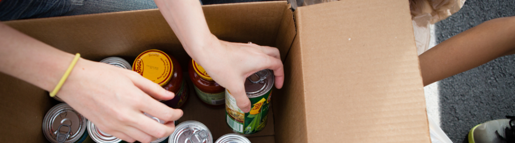 People putting cans of food into a box