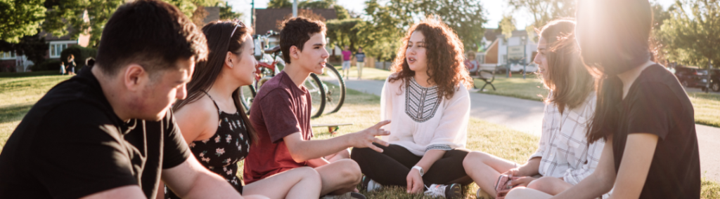 Kids sitting outside in a circle