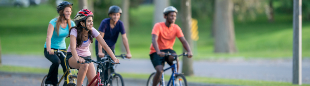 Four people riding their bikes outside