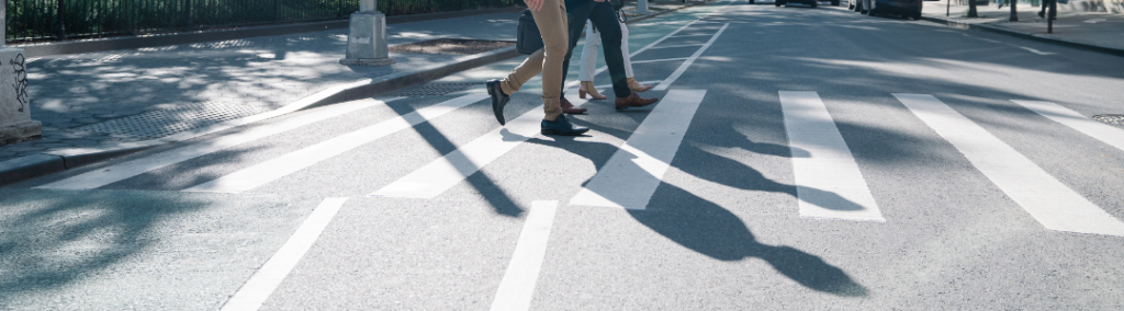 Shadows of people walking on a crosswalk