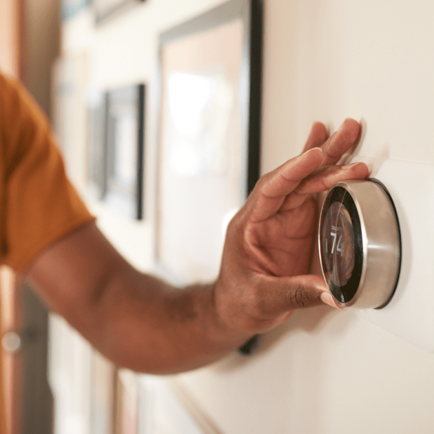 Man adjusting smart thermostat